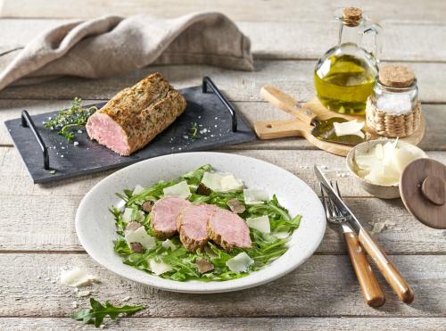 Roasted veal tenderloin with rocket and parmesan flakes in olive oil, refined with truffle