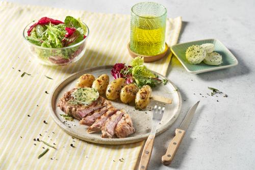 Veal cutlet with herb butter, rosemary potatoes and small salad